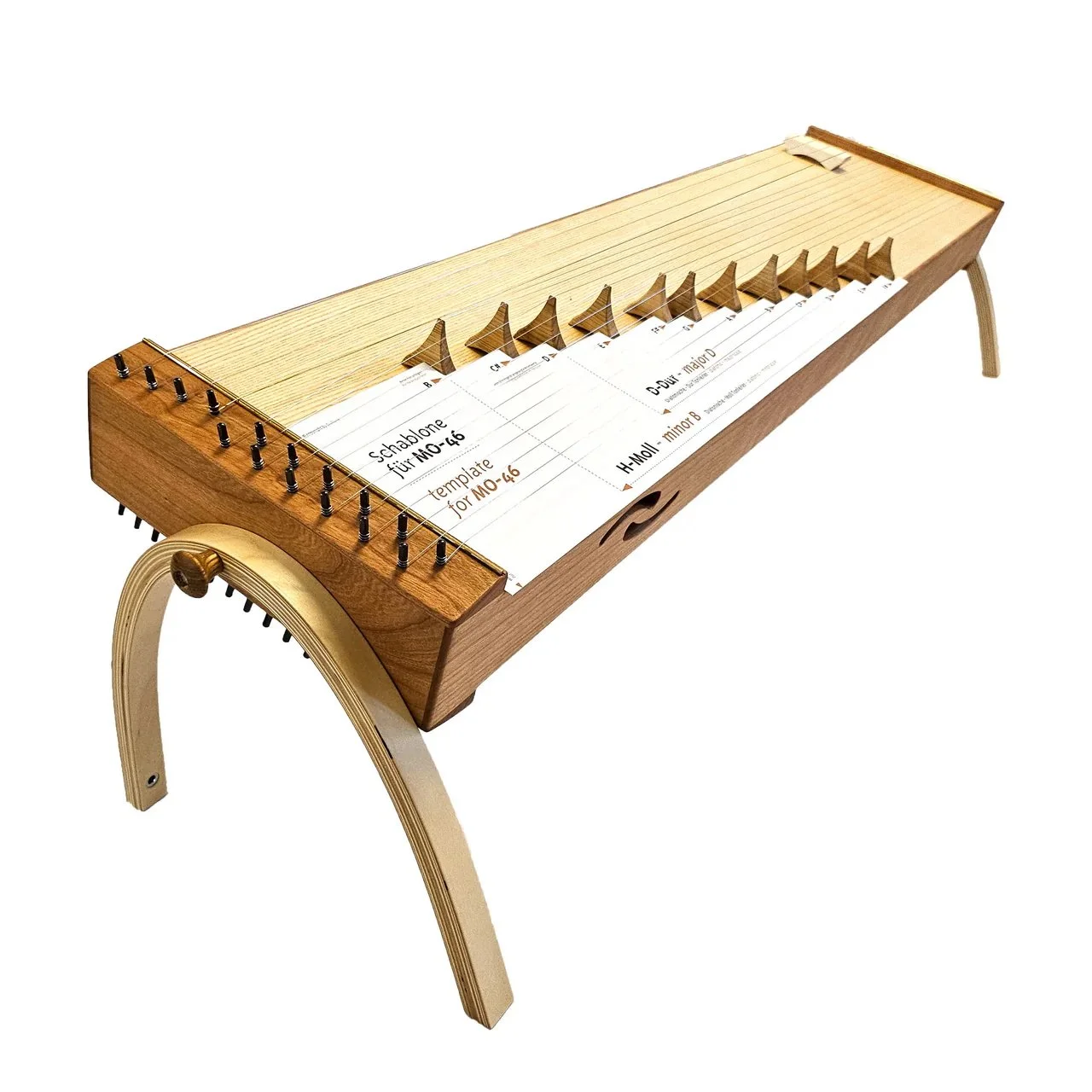 A wooden zither musical instrument with tuning pins, strings, and a music sheet attached, supported by wooden stands.