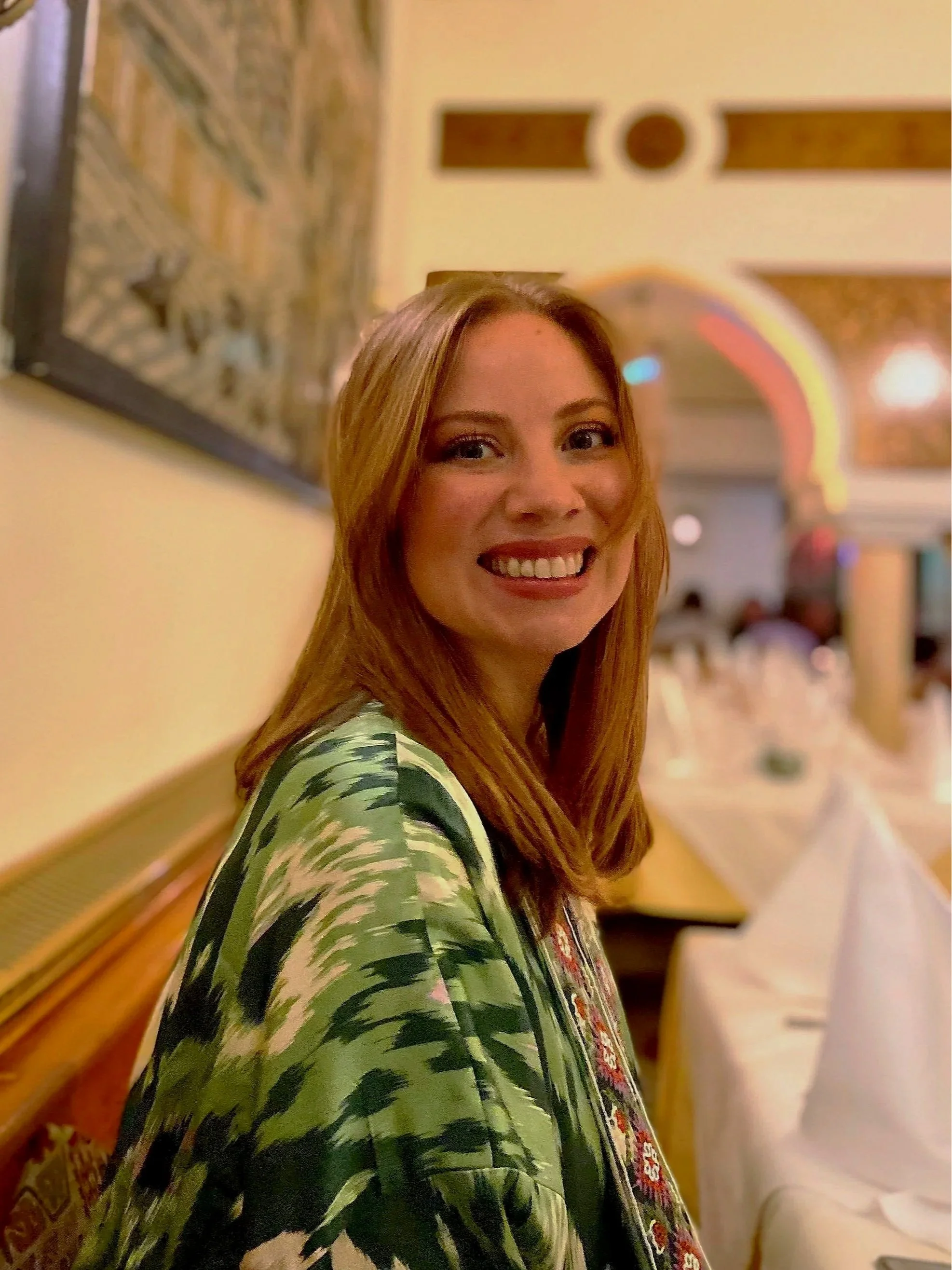 Casey Marie smiling at camera with a gallery in the background.