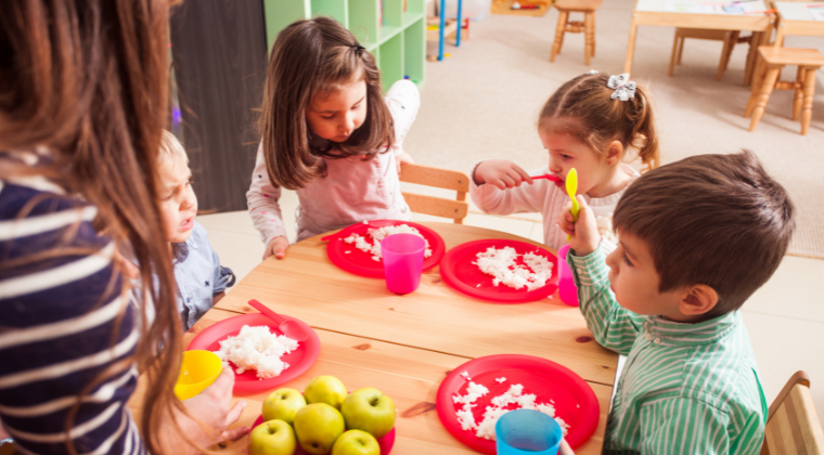 Kids in a daycare with white food in front of them