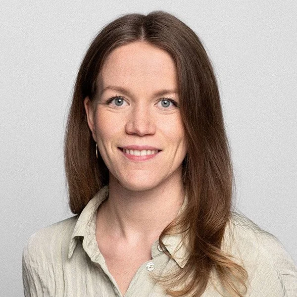 Nina Holm, Psychologische Psychotherapeutin, blickt frontal, lächelnd, trägt beiges Hemd.