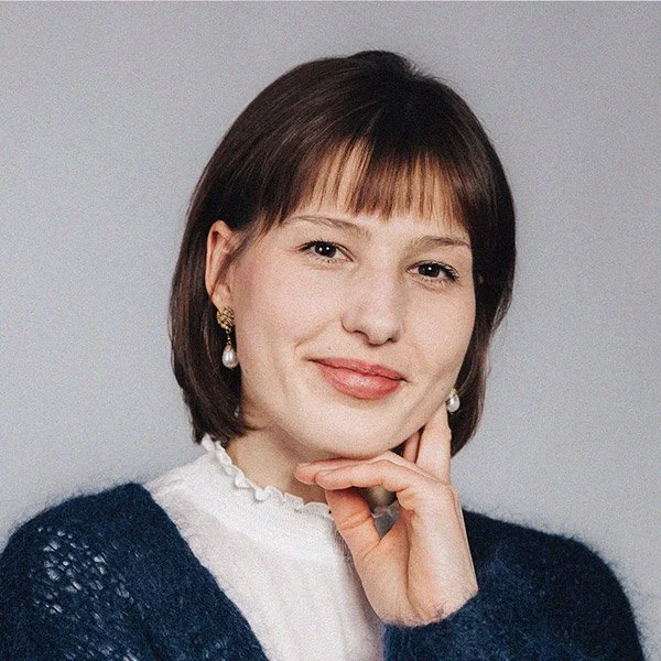 Lisa Haselberger, Finanzleitung und Buchhaltung, blickt freundlich, schulterlanges braunes Haar, trägt Ohrringe, weißes Hemd und blaue Strickjacke.