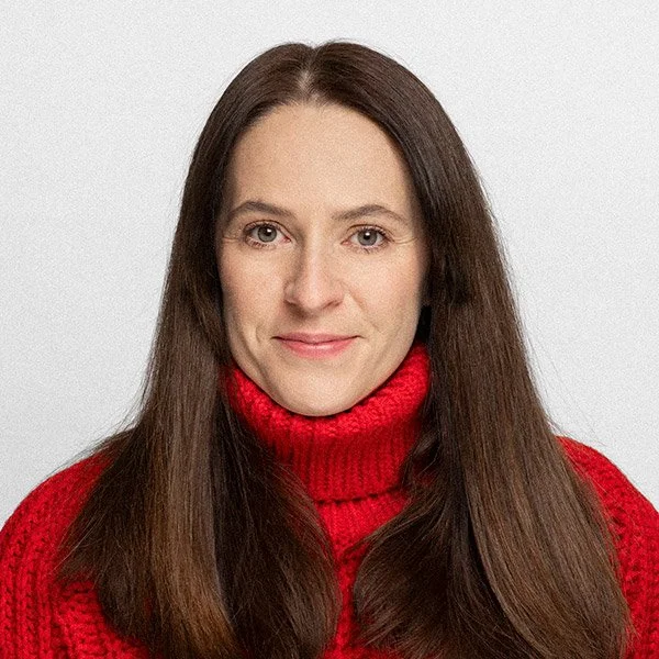 Cosima Blazickova, Psychologische Psychotherapeutin, frontal freundlich blickend, langes braunes Haar, trägt roten Rollkragen Pullover.