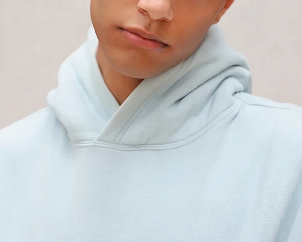 Junger Mann in Kapuzenpullover, Blick nach unten, symbolisch für Nachdenken oder Selbstreflexion