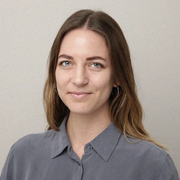 Laura Kadereit, Psychologische Psychotherapeutin, freundlicher Blick, blaue Augen, trägt Ohrringe und hellgraues Hemd.