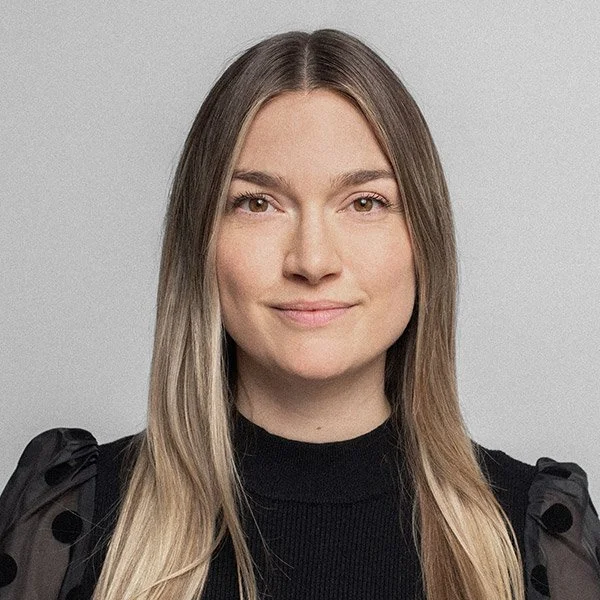 Lara Nicolini, Psychologische Psychotherapeutin, freundlich blickedn, lange Haare, schwarzes Oberteil mit ausgestellten Ärmeln.