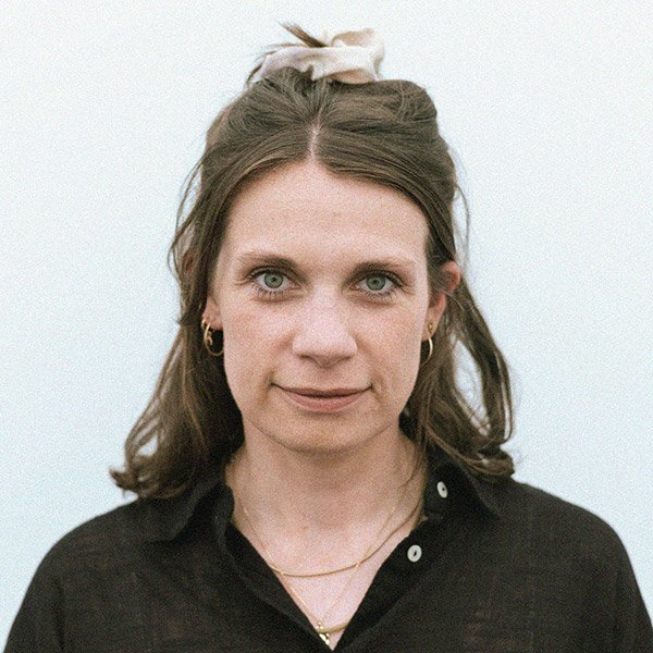 Anna Schwieger, Psychologische Psychotherapeutin, blickt forntal, zugewandt, trägt Ohrringe und schwarzes Hemd