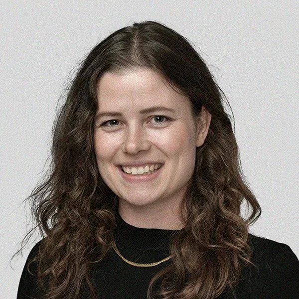 Rebecca Müller, Psychologische Psychotherapeutin, lächelnd, lange gewllte Haare, trägt Kette und schwarzen Pullover