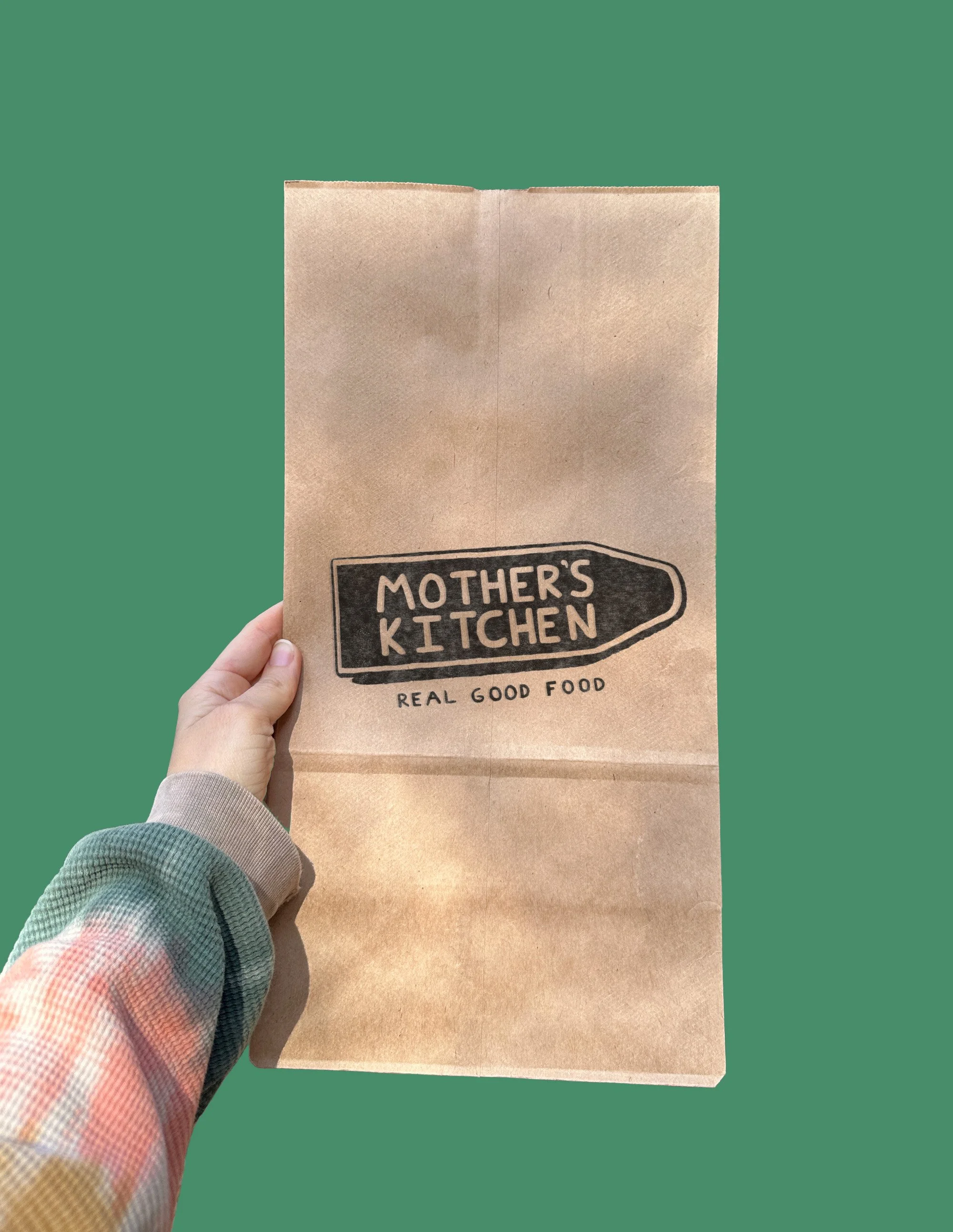 Mockup of hand holding mothers stamped bag.jpg