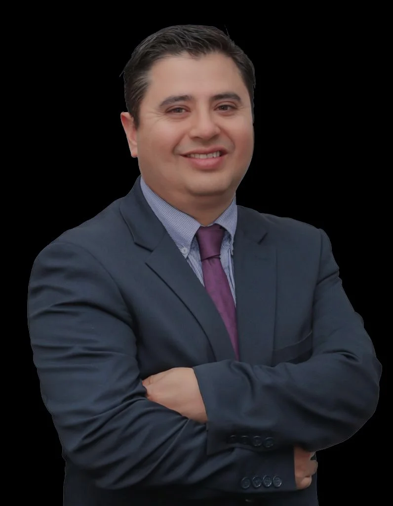 Hombre con traje y corbata sonriendo con brazos cruzados contra fondo negro.