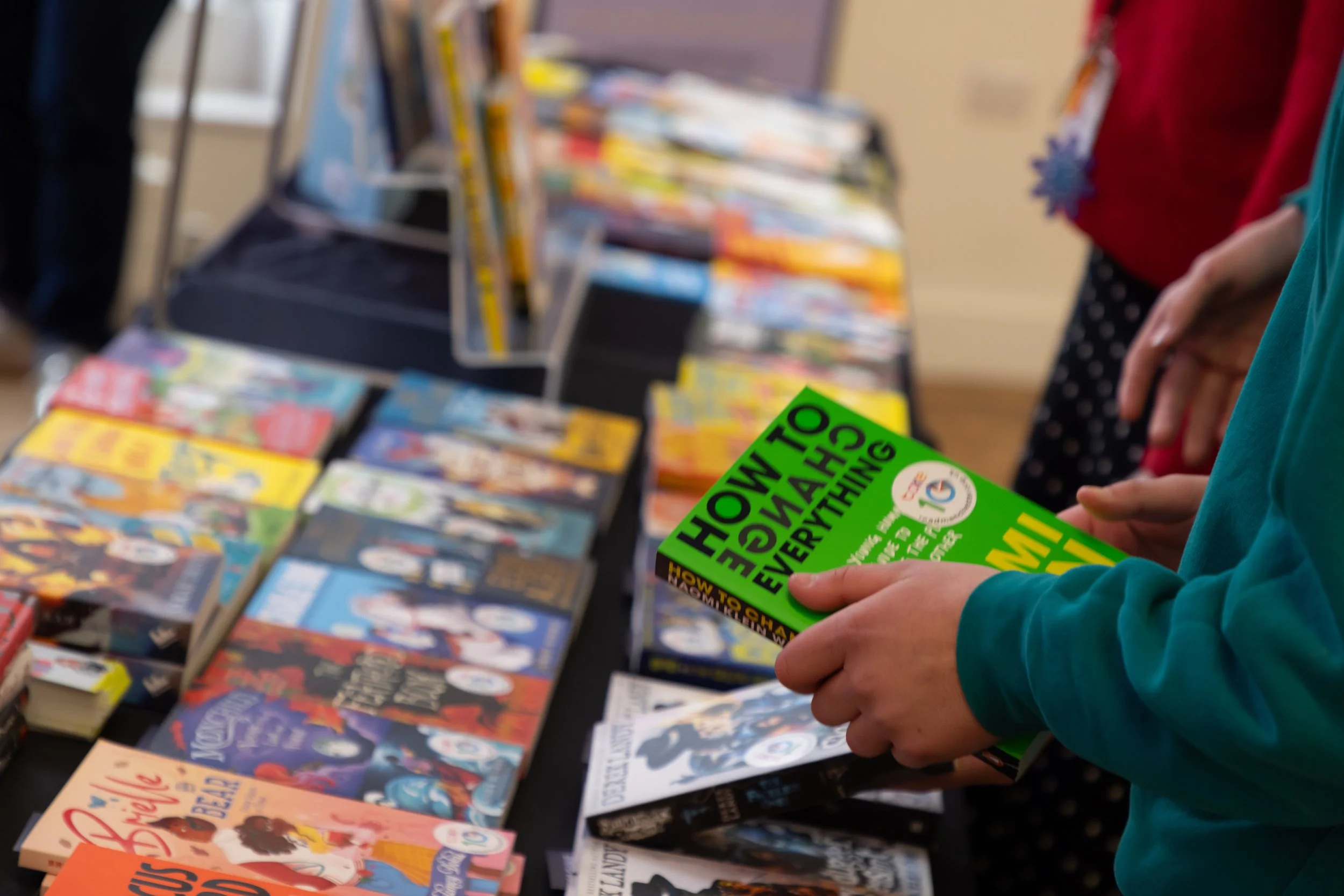 Hands holding a book and table of books.jpg