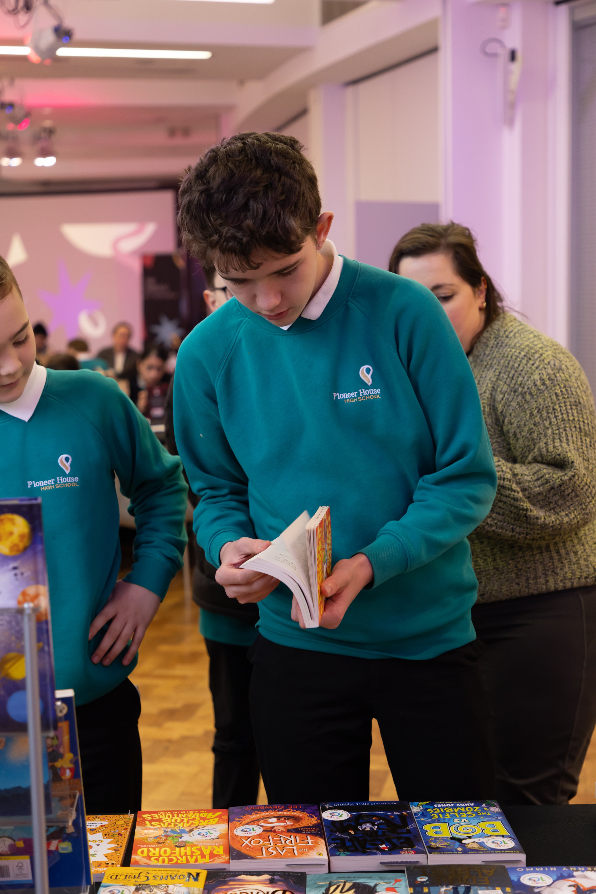 Pioneer House students flipping through book.jpg