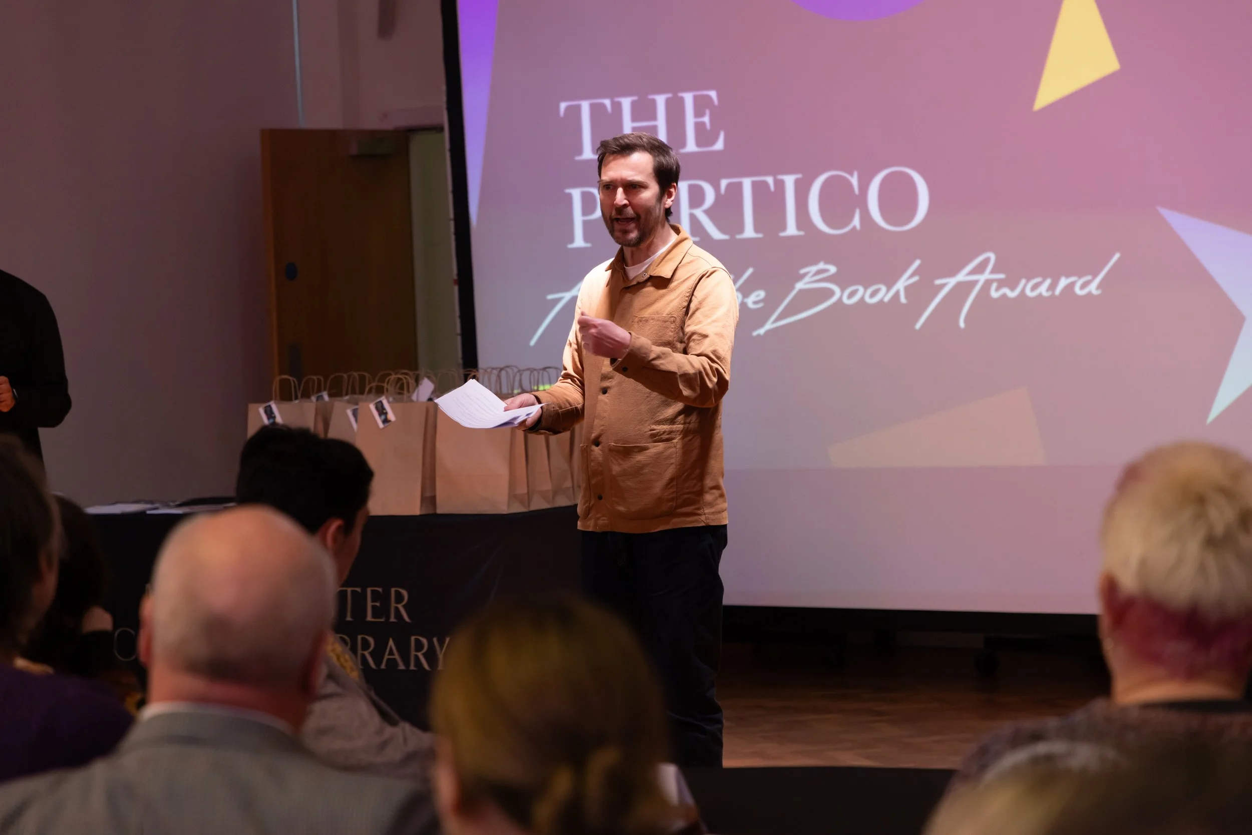 Oliver East, paper in hand, talking.jpg