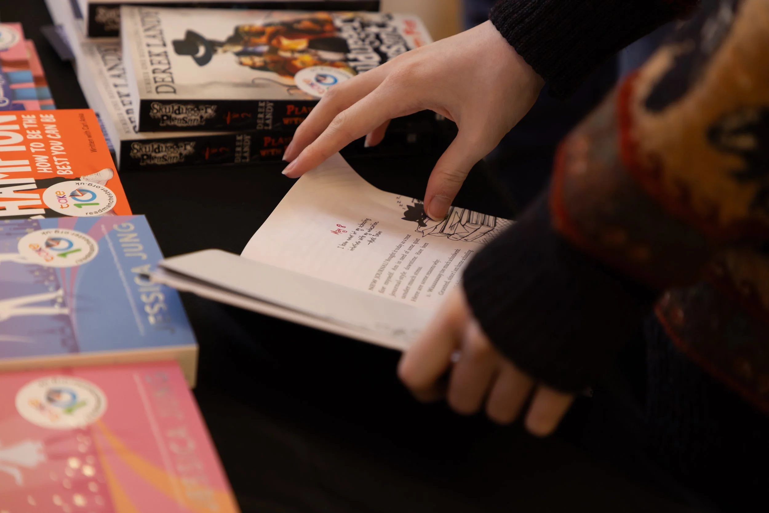 Hands, open book at book table.jpg