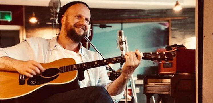 Jon Green playing guitar and singing