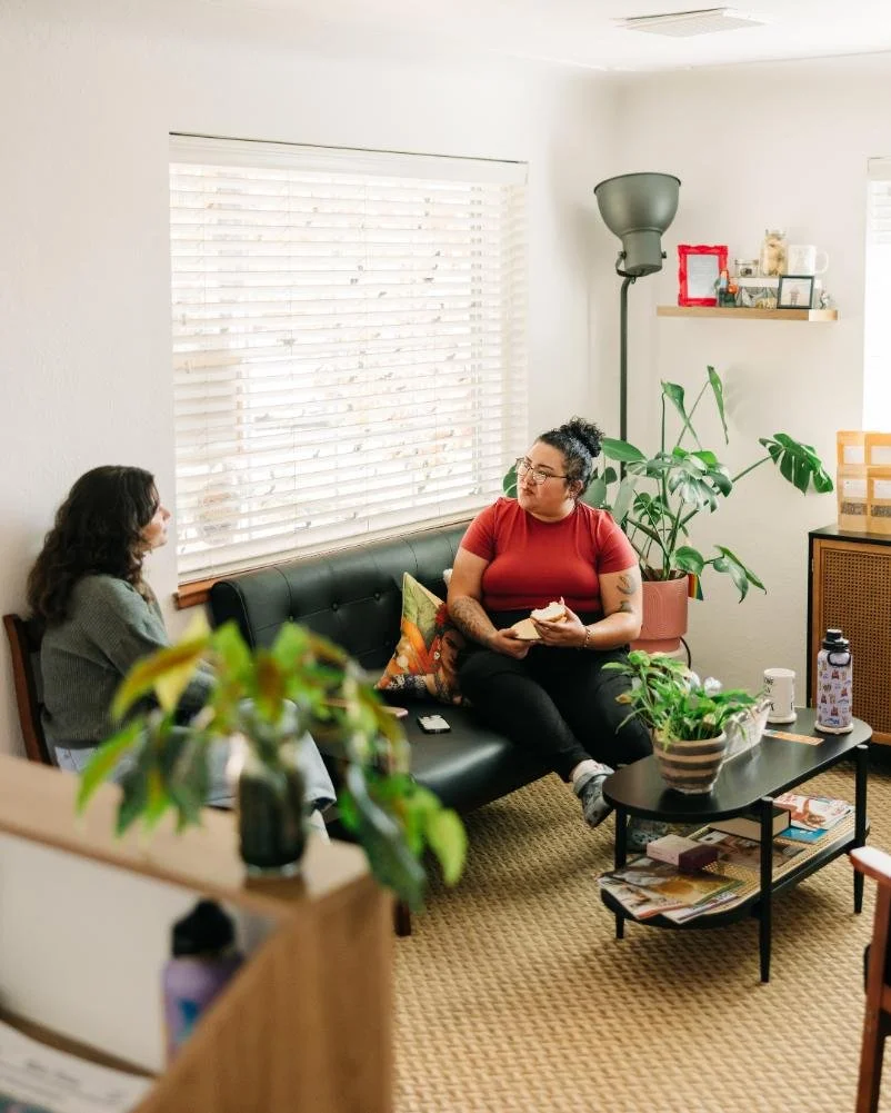 Two persons sitting on a couch in a chiropractors office