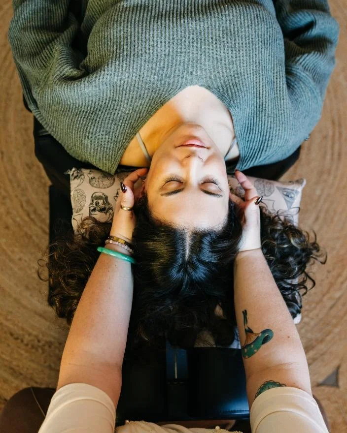 Woman with dark brown curly hair getting a massage.