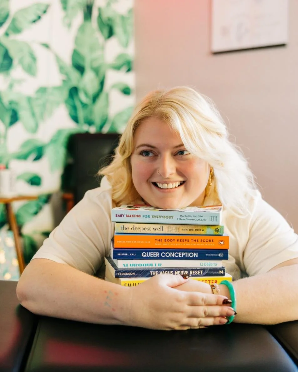 Dr. Savannah smiling while holding fertility books