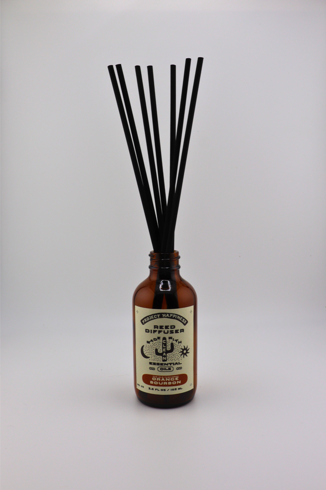 Old Fashioned Orange Bourbon Reed Diffuser in an amber glass bottle with 7 black reeds, featuring bright notes of lemon peel, whiskey, citrus, peach, sugar, and smoke. Lasts 3–4 months.