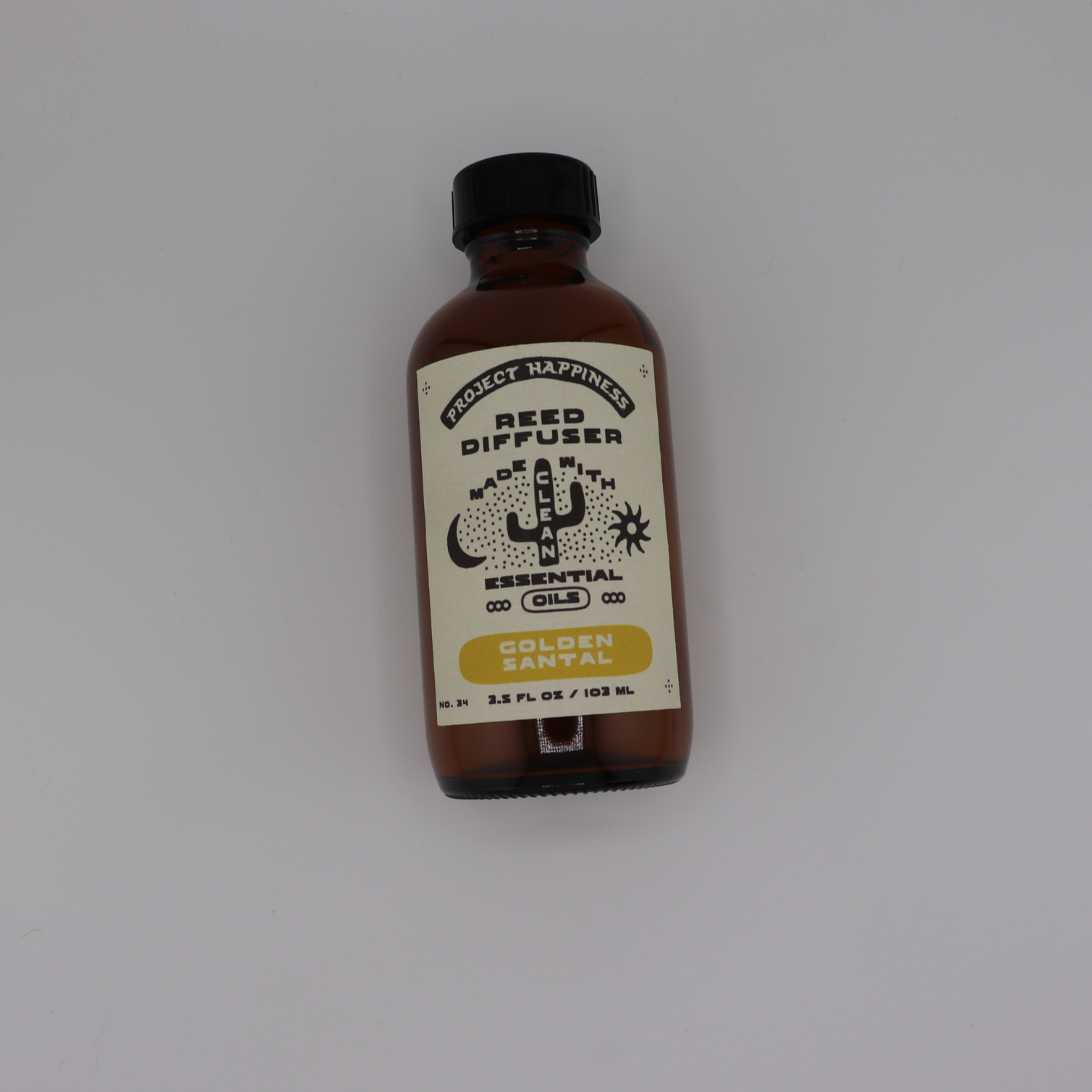 Golden Santal Reed Diffuser in an amber glass bottle with black reeds, featuring herbal notes of fennel, sage, cedar, amber, balsam, and sandalwood. Lasts 3–4 months.