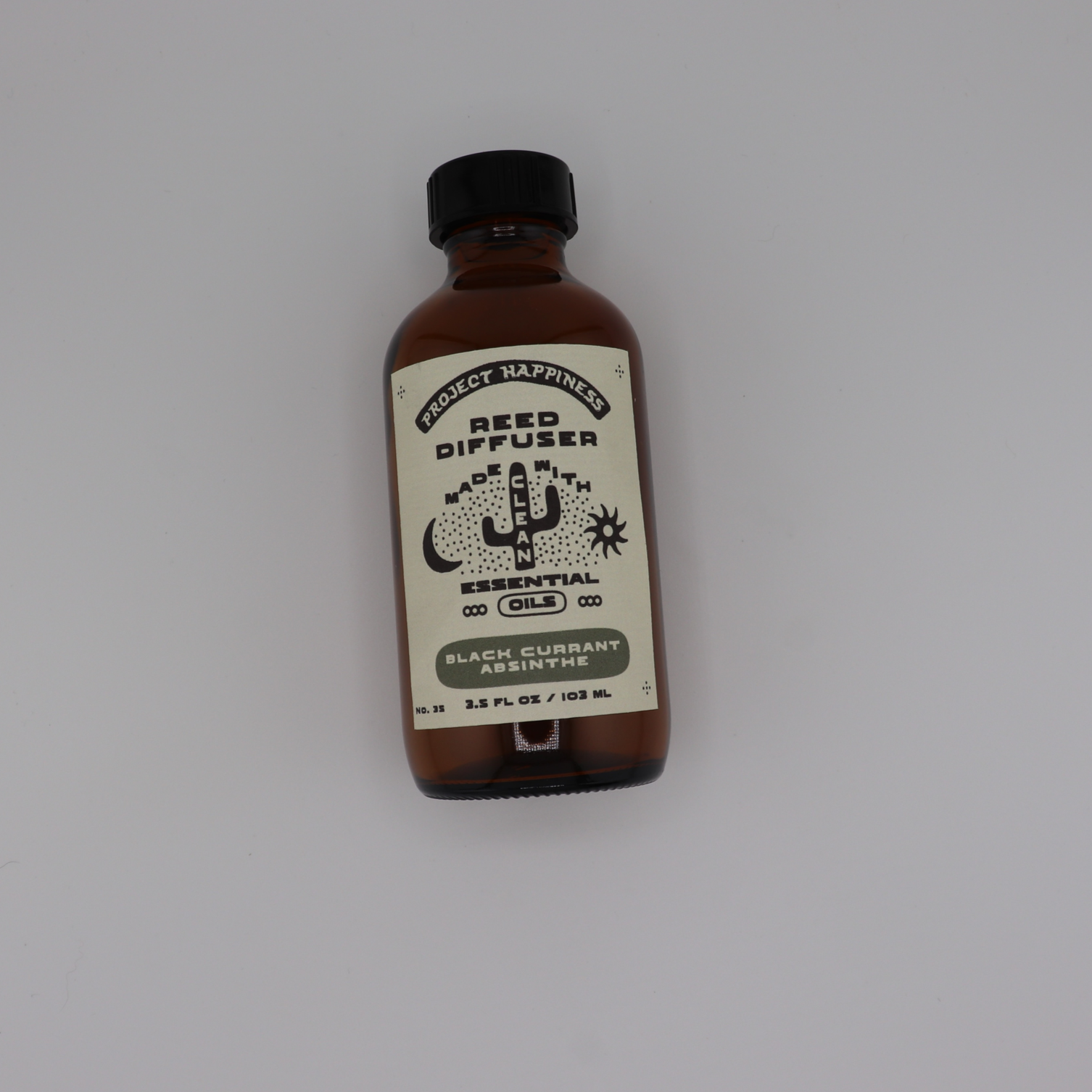 Black Currant Absinthe Reed Diffuser in an amber glass bottle with black reeds, featuring dark notes of black currant, oud, amber, smoke, myrrh, and musk. Lasts 3–4 months.