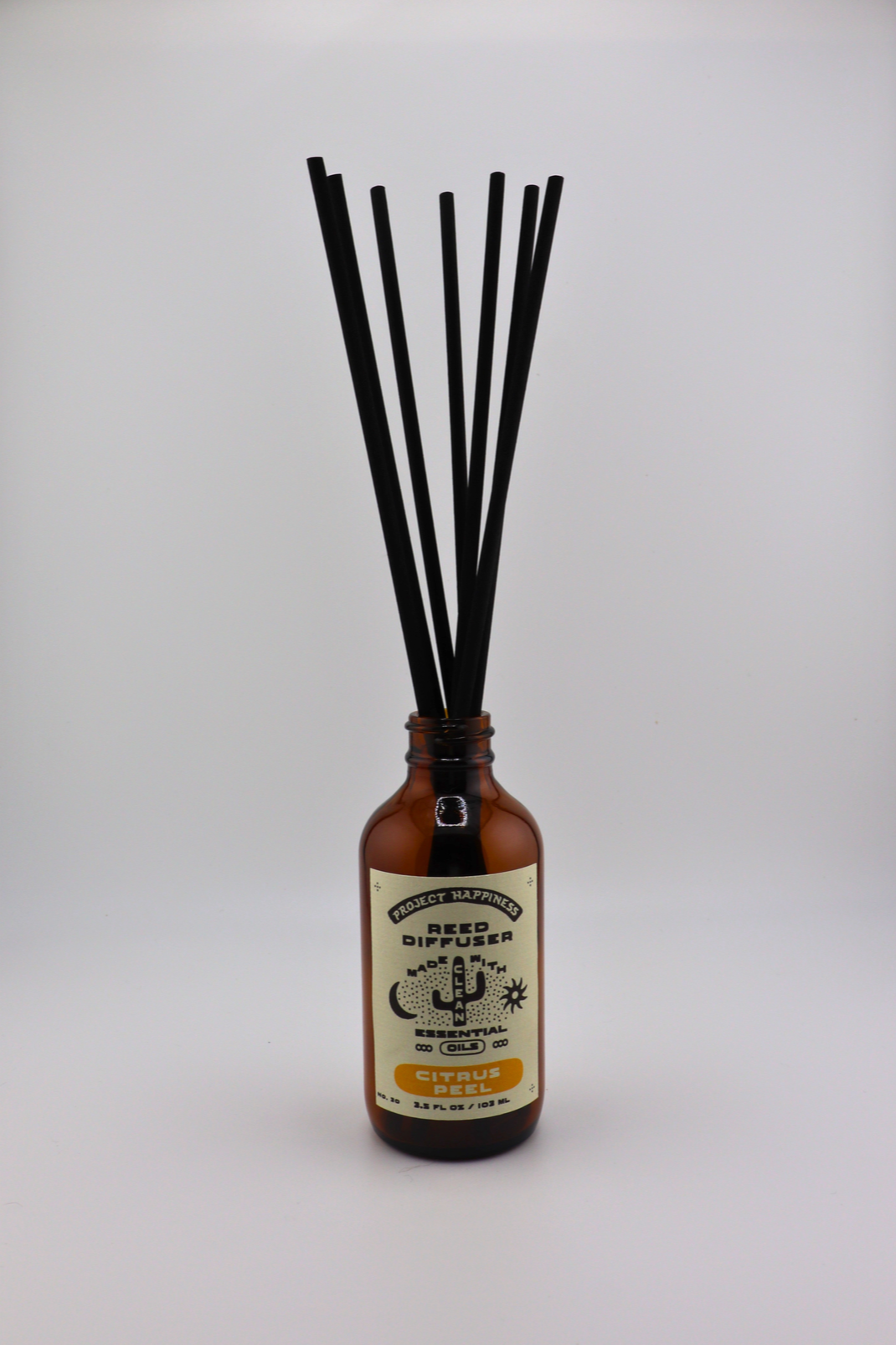 Citrus Peel Reed Diffuser in an amber glass bottle with 7 black reeds, featuring bright notes of orange peel, grapefruit, lemon, and cedar for a fresh, uplifting fragrance. Lasts 3–4 months.