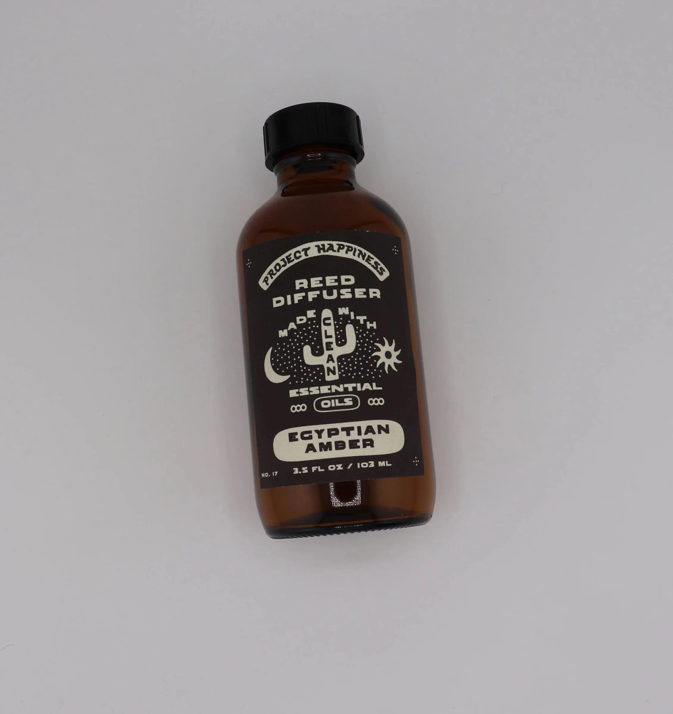 Egyptian Amber Reed Diffuser in an amber glass bottle with black reeds, featuring warm notes of amber, sandalwood, patchouli, jasmine, musk, and tonka bean. Lasts 3–4 months.