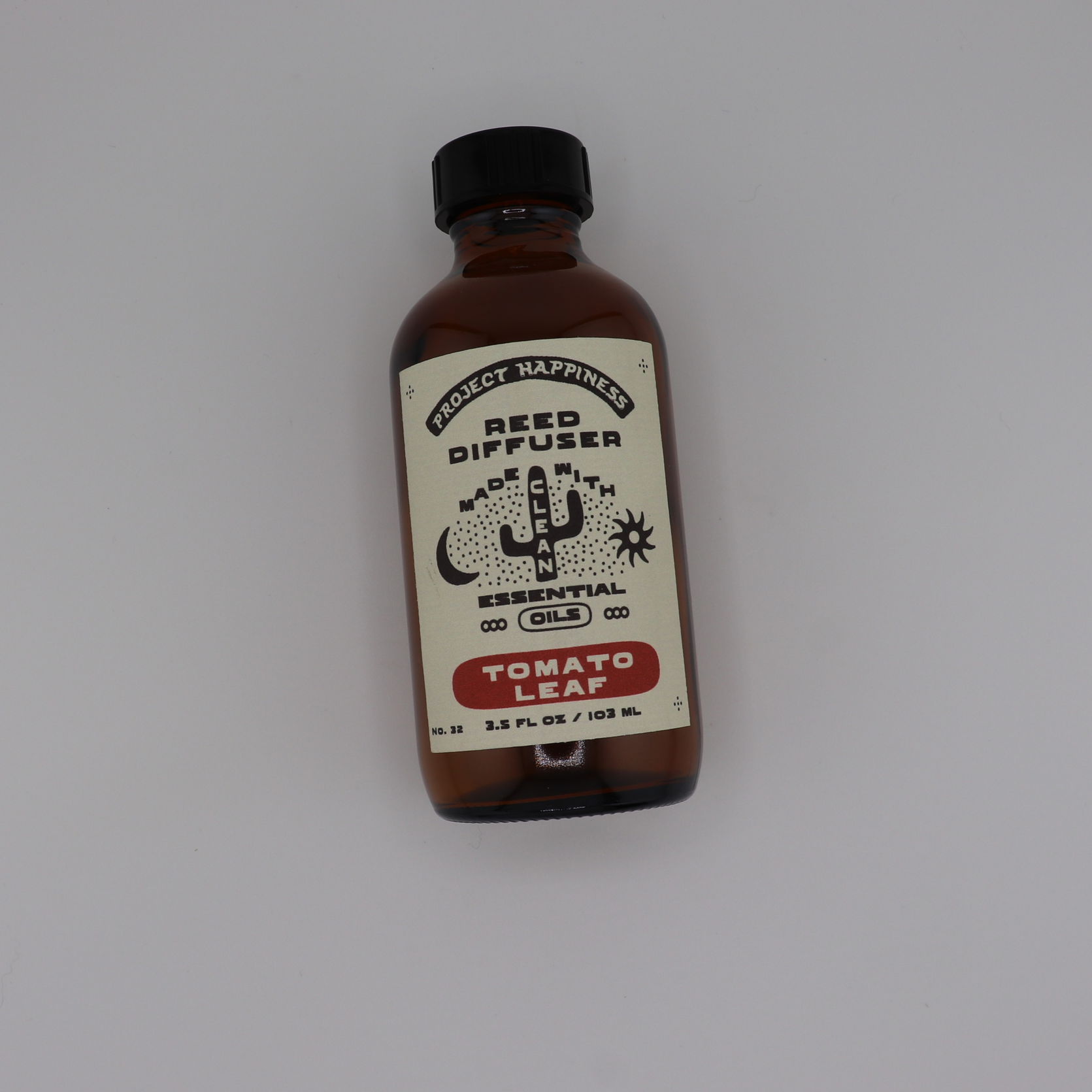 Tomato Leaf Reed Diffuser in an amber glass bottle with black reeds, featuring fresh notes of tomato leaf, lemon peel, basil, thyme, lemongrass, and moss. Lasts 3–4 months.