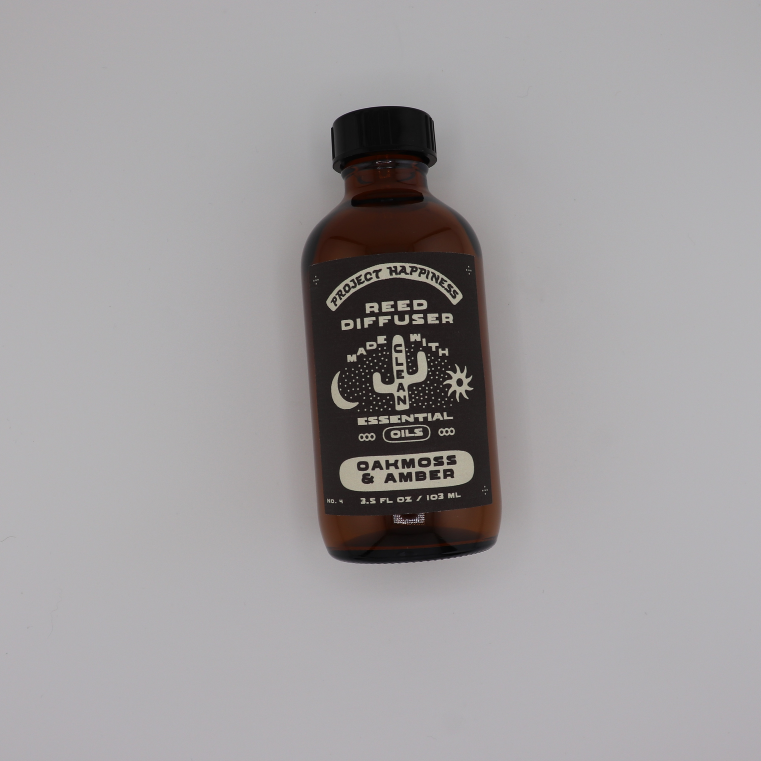 Oakmoss & Amber Reed Diffuser in an amber glass bottle with black reeds, featuring fresh sage, grapefruit, lavender, oakmoss, amber, and tonka bean. Lasts 3–4 months.