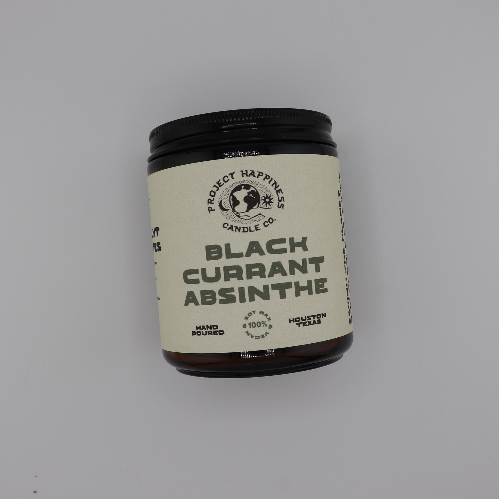 Black Currant Absinthe soy candle in an amber glass jar, featuring dark notes of black currant, blackberry, smoke, oud, amber, myrrh, and musk. Burns for 45–50 hours.