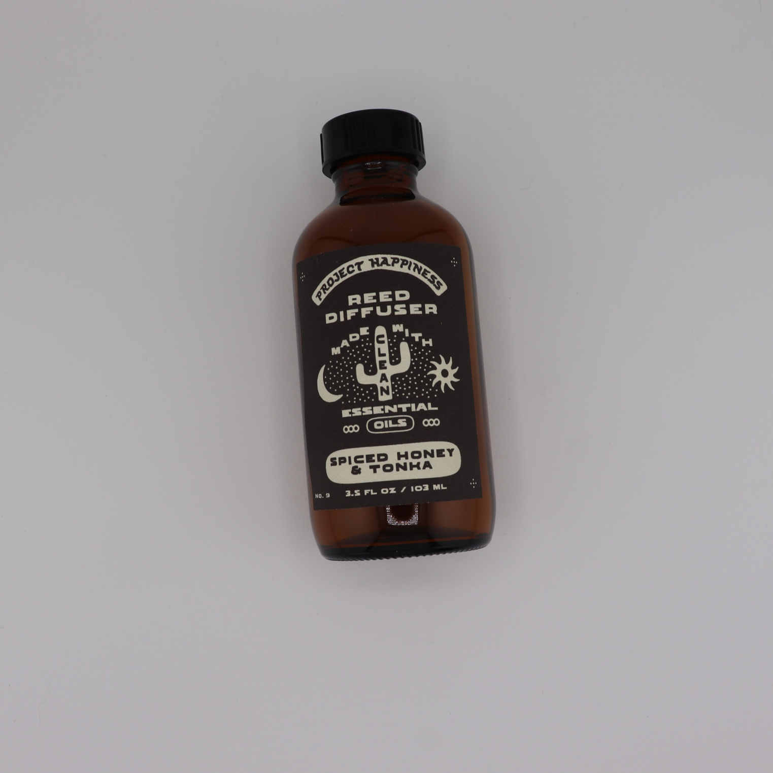 Spiced Honey & Tonka Reed Diffuser in an amber glass bottle with 7 black reeds, featuring warm notes of honey, amber, tonka bean, oud, and tobacco for a cozy, inviting fragrance. Lasts 3–4 months.