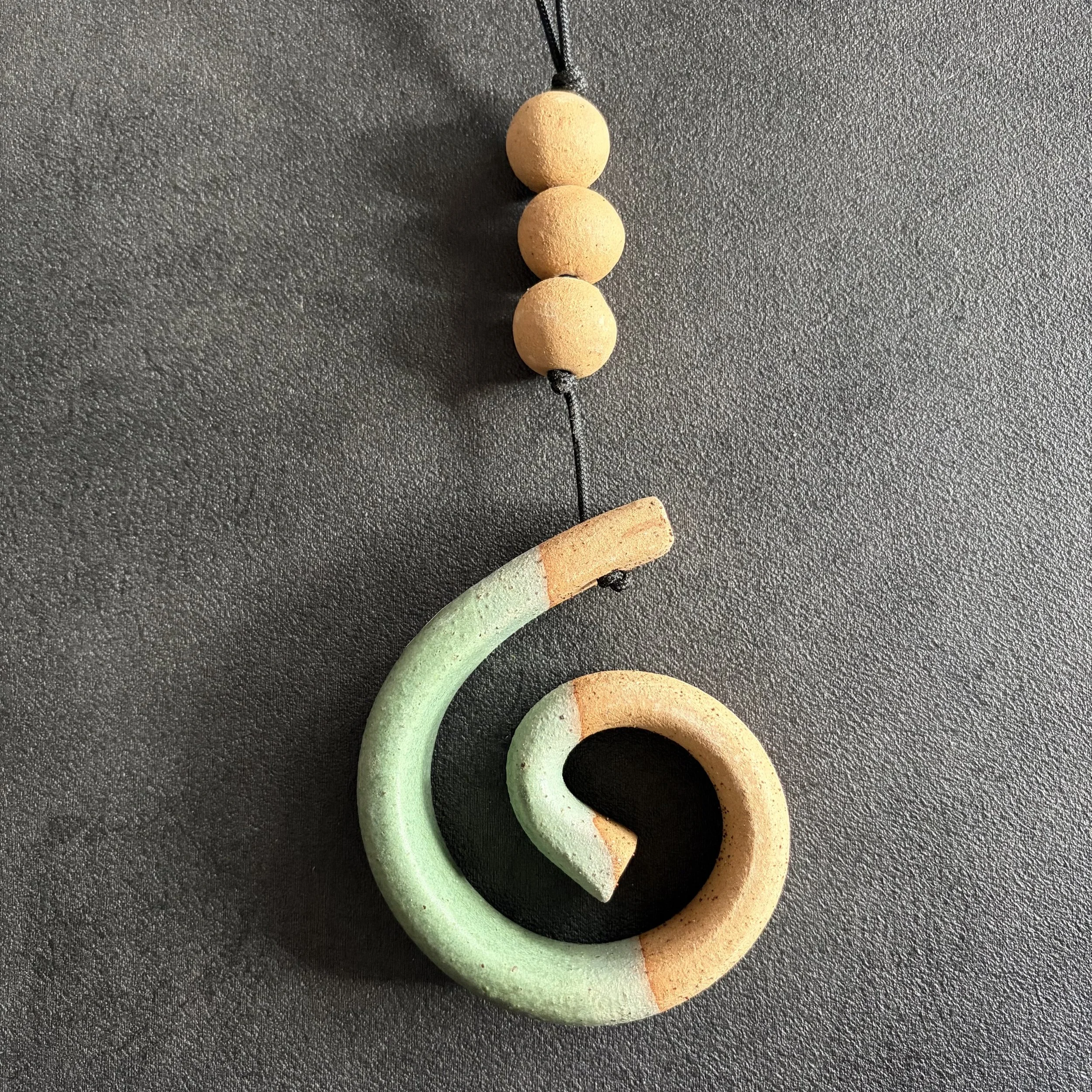 small hanging koru . green