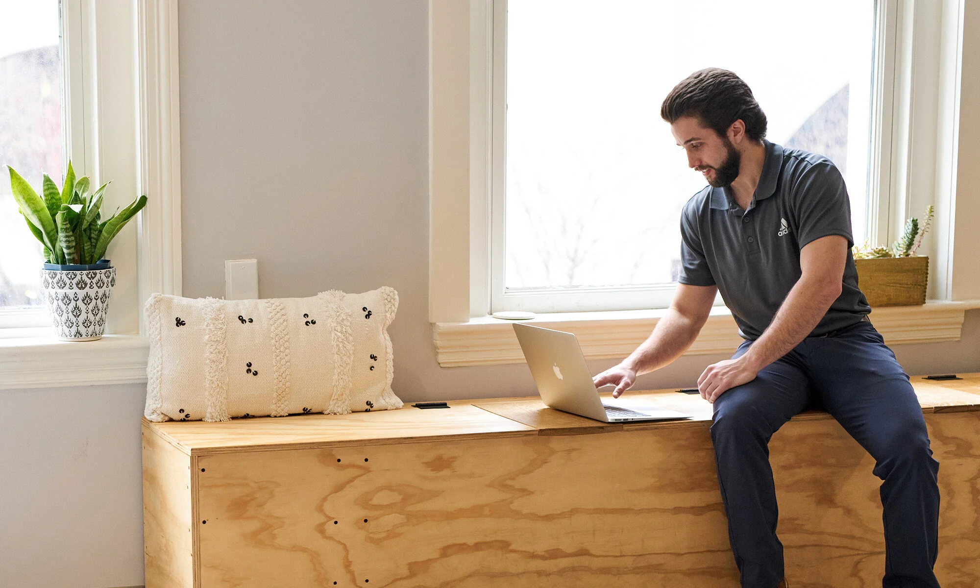 Back Bay Health physical therapist sits by window on virtual call.