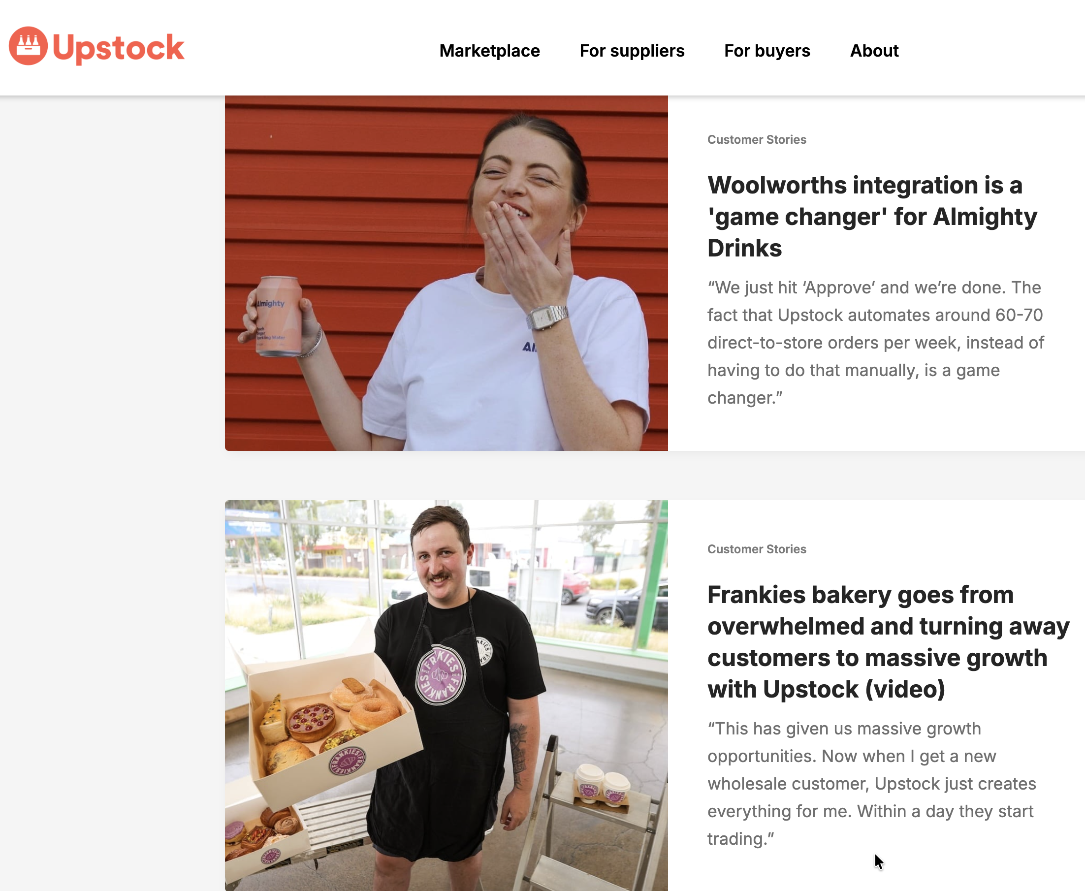 A woman with brown hair in a ponytail, wearing a white shirt and a wristwatch, holds a box of assorted donuts and treats in front of a large window. She is smiling and appears happy, with a bakery setting behind her.