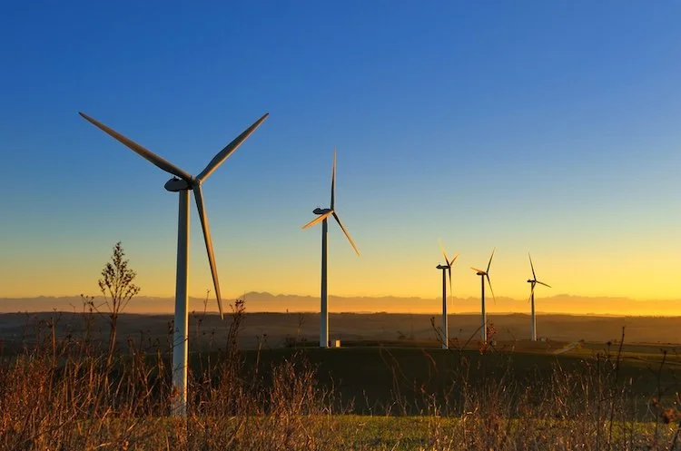 Five wind turbines in a scenic landscape