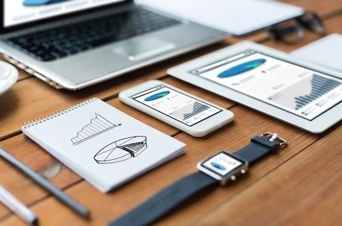 Modern desk with devices showing charts