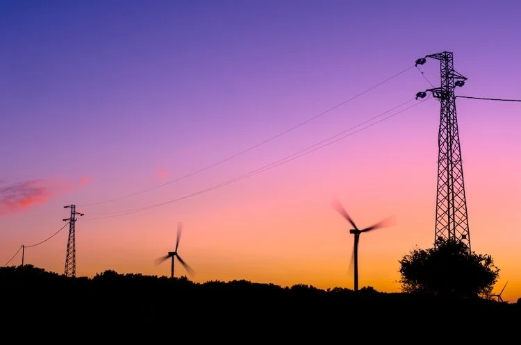 Light purple sky with windmills and electricity towers