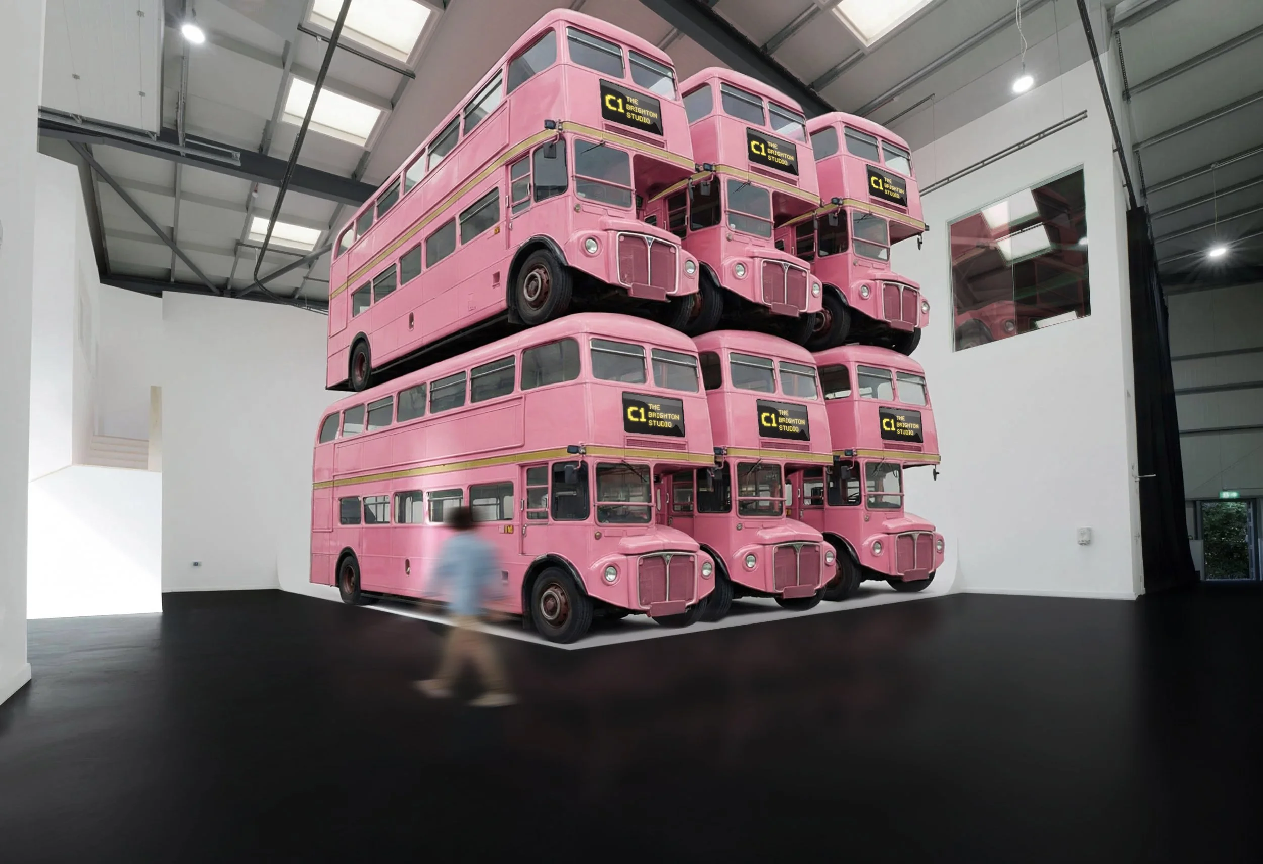 Studio A is large enough to accommodate x6 double decker buses. The image is a visualiser of this and shows six pink London buses stacked on top of each other on the white shooting stage