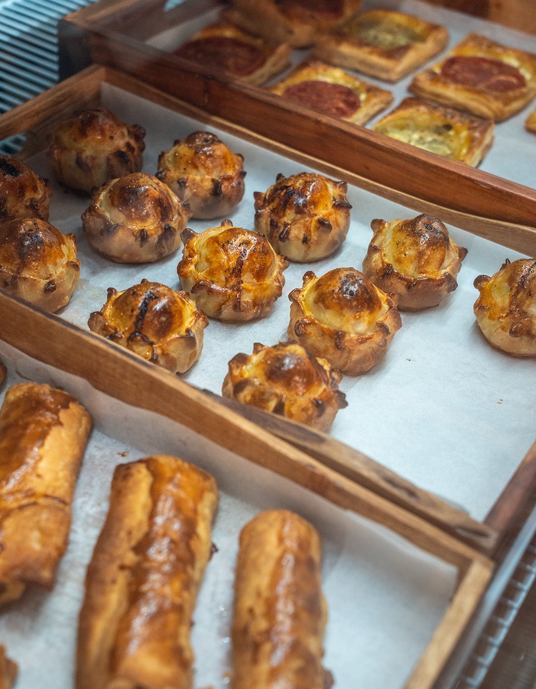 A deli case featuring savory meat pies at a cafe.