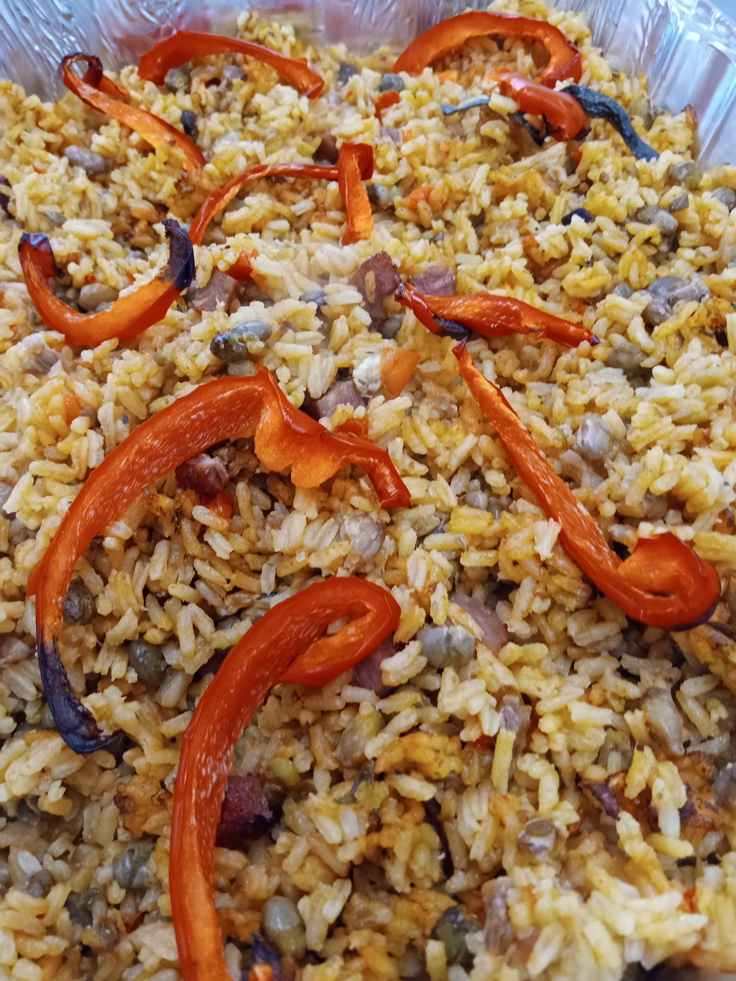 Cooked fried rice with red bell pepper slices on top.