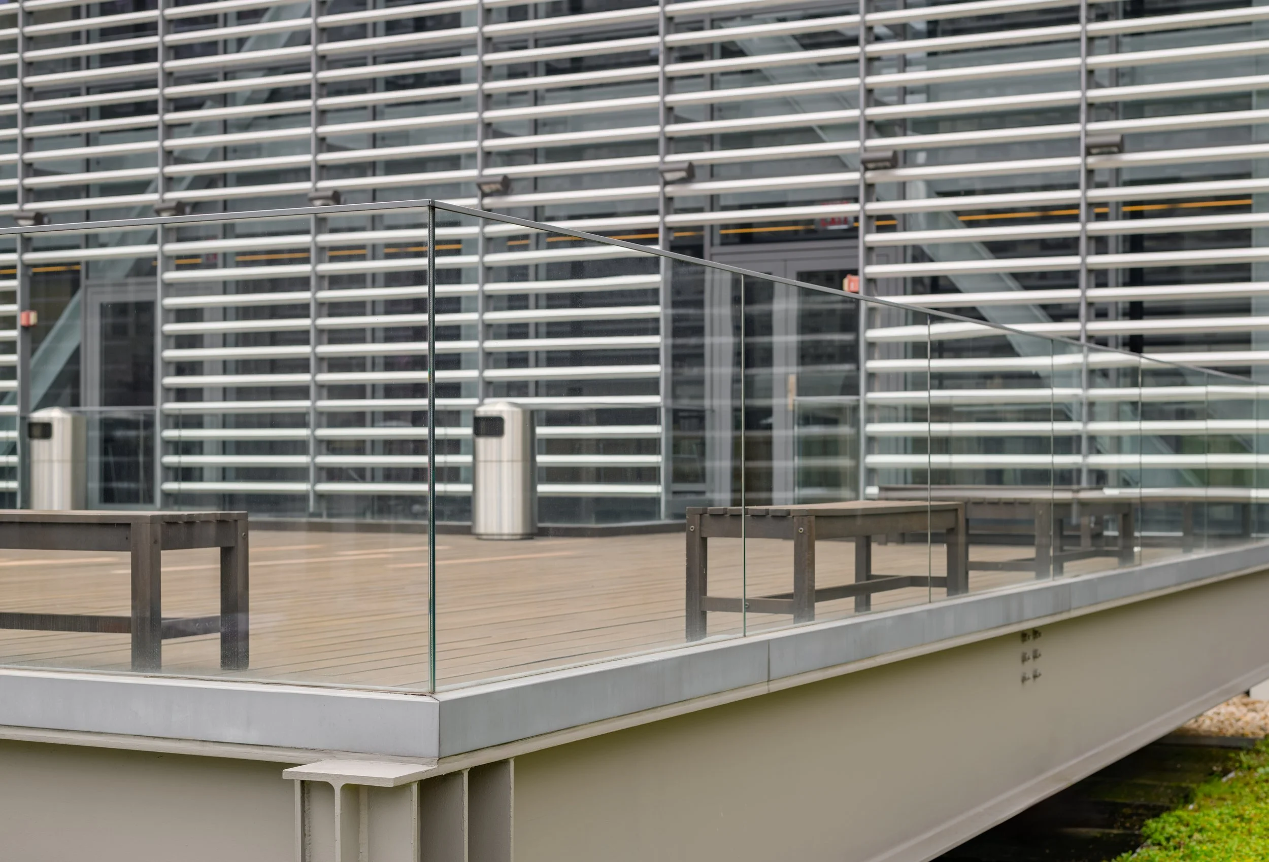 Modern spiral staircase with glass railing and geometric ceiling, interior setting