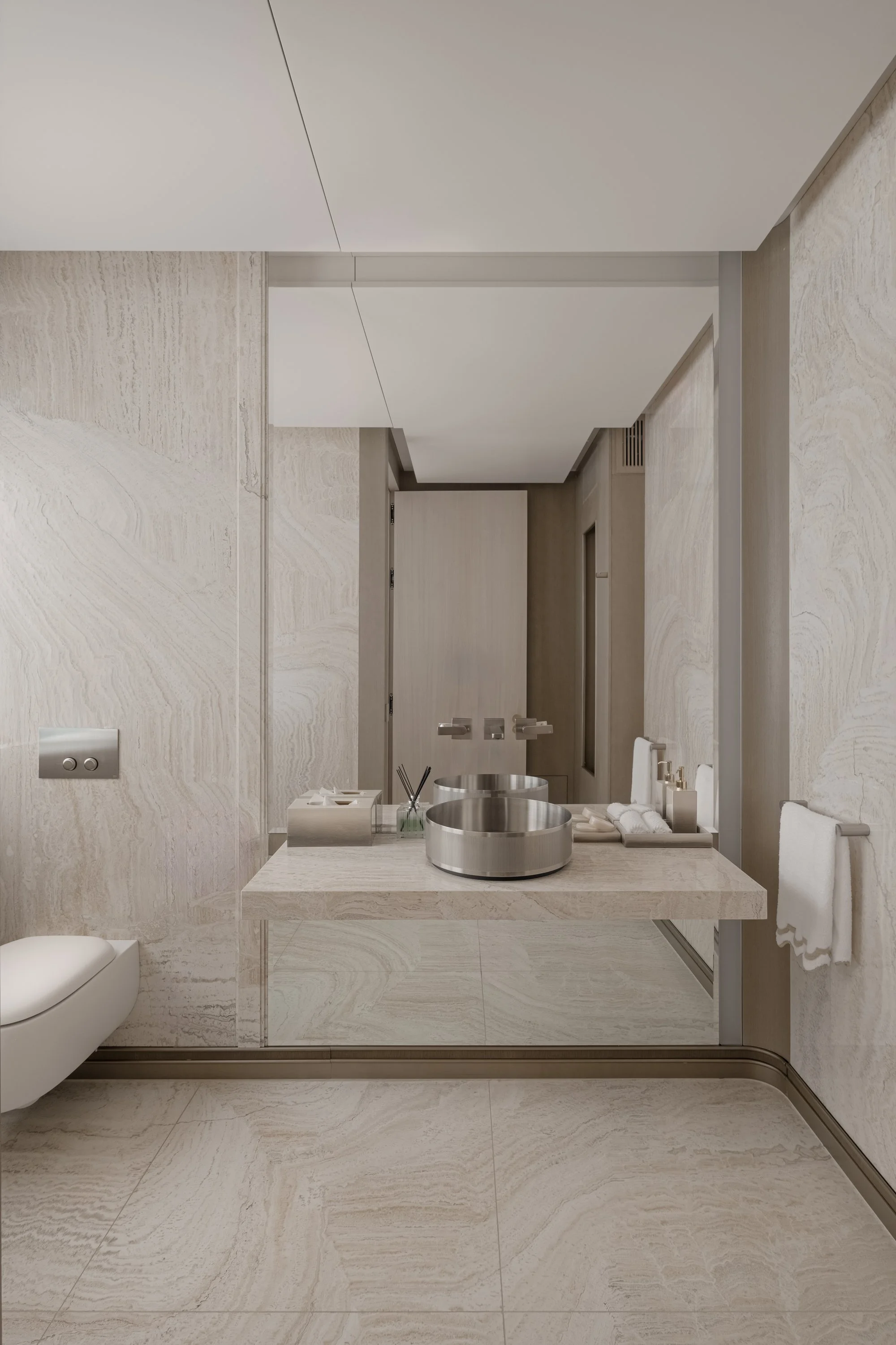 Modern bathroom with two identical white vanities, each with mirrors and sinks, a central door, marble floor, large windows, and leaf-themed wall art.