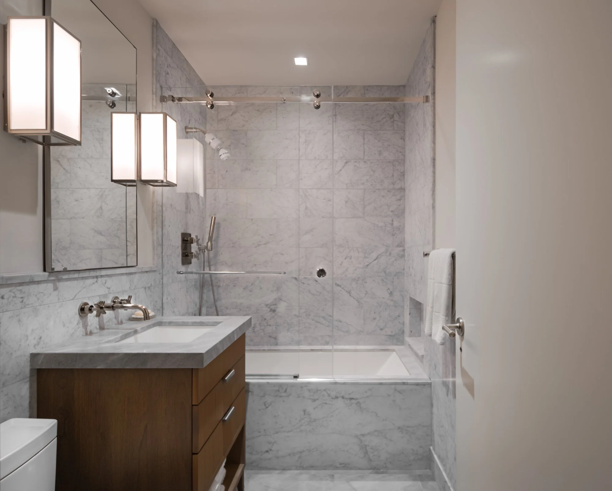 Modern bathroom with glass-enclosed shower and freestanding bathtub