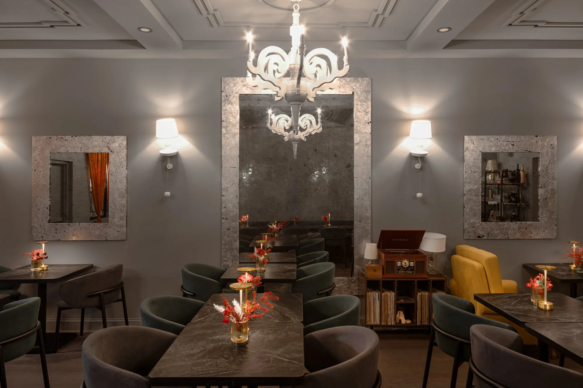 Minimalist interior with large mirror reflecting a window, gray ceramics, and a potted plant.