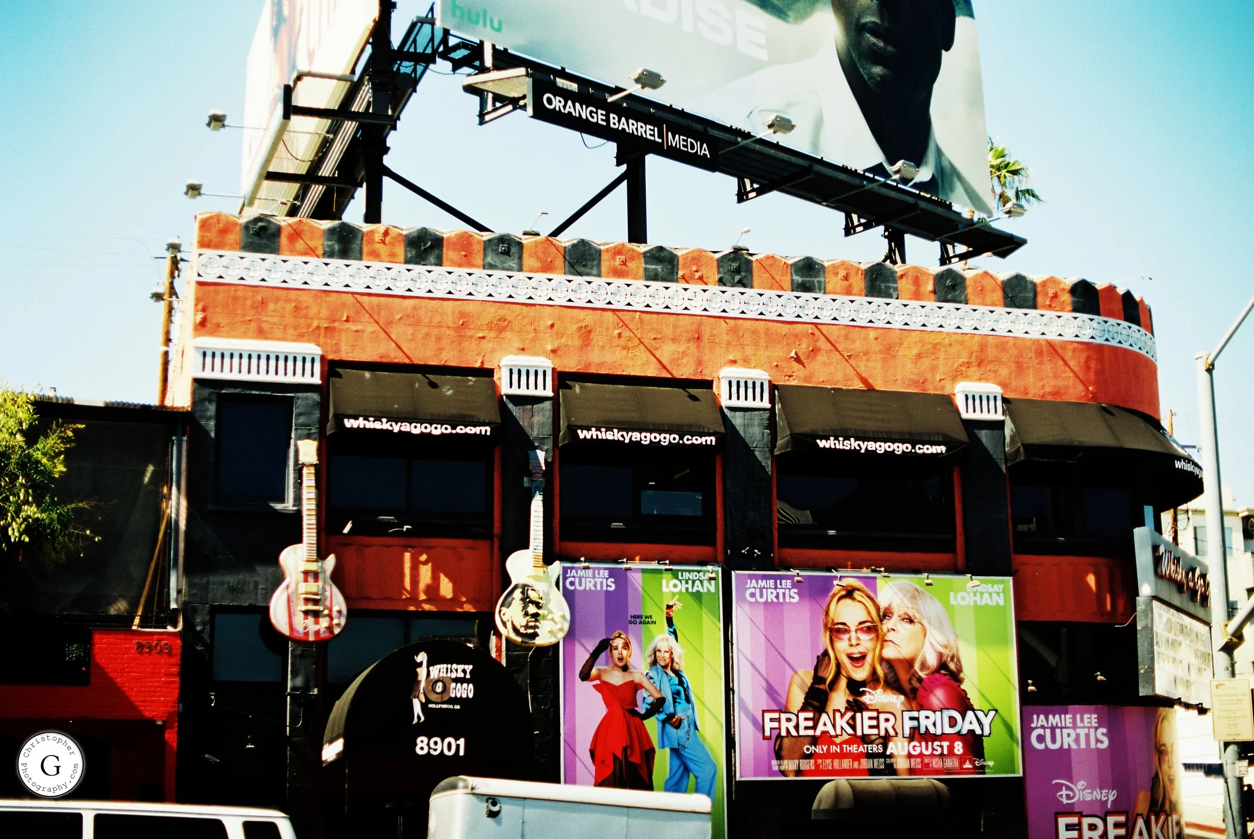 Billboard on a building advertising the movie 'Freakier Friday' starring Jamie Lee Curtis and Lindsay Lohan, with posters of the film and a large image of two women, one with glasses, both smiling shot on 35mm film .