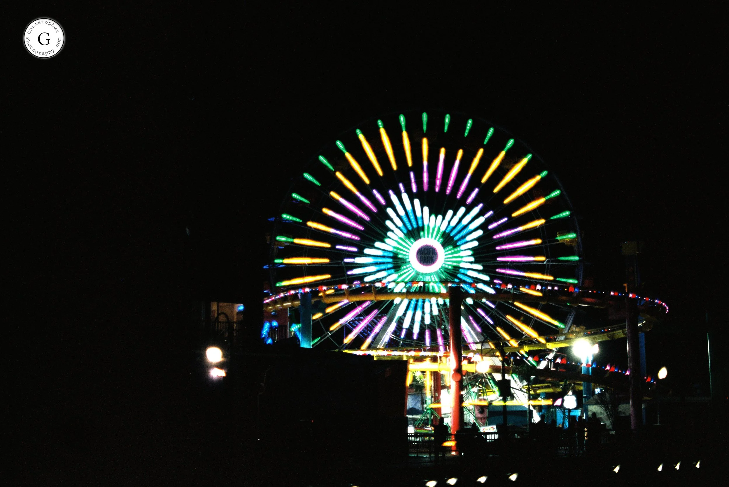 Colorful illuminated Ferris wheel at night shot on 35mm film .