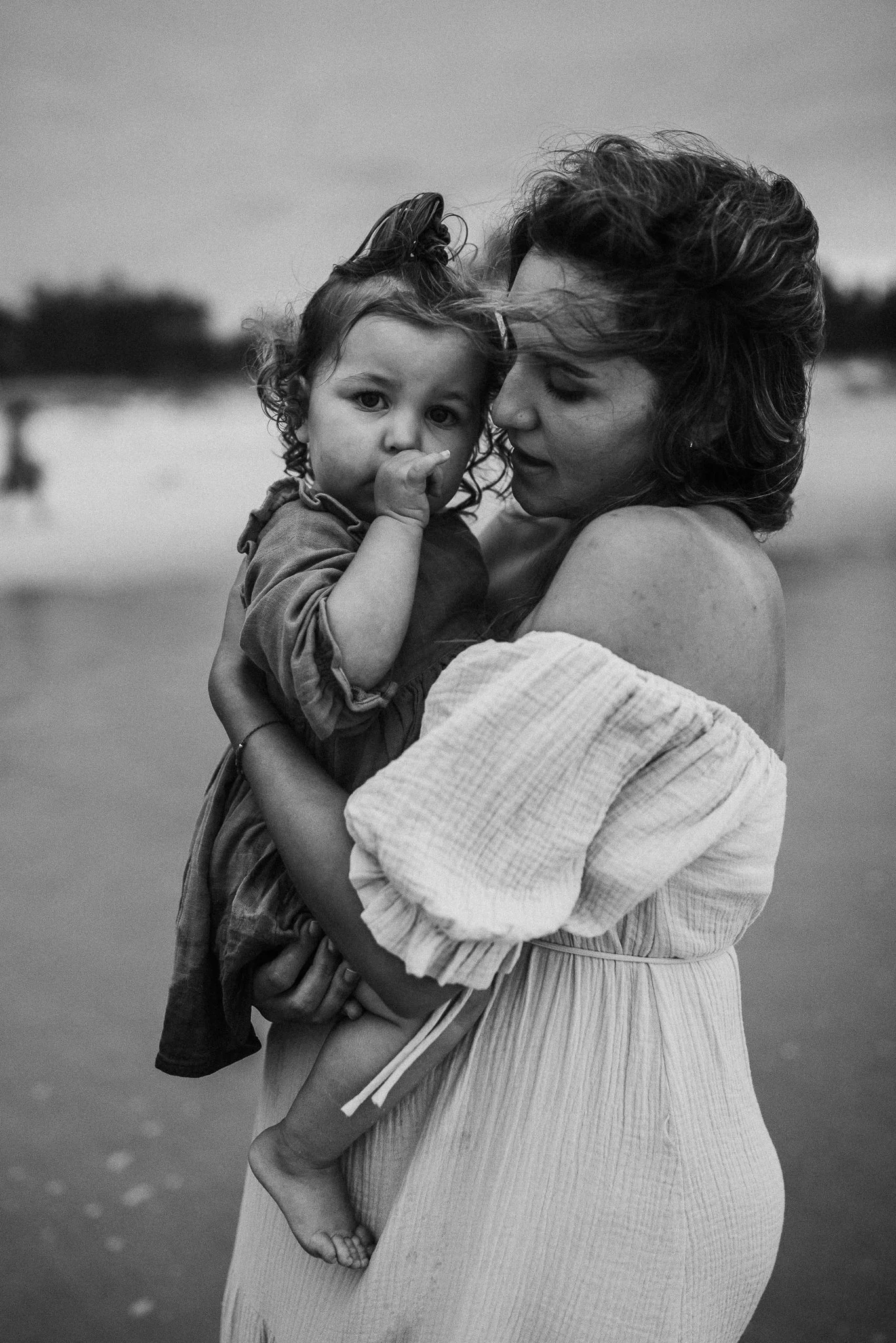 Mother holding child at the beach in black and white