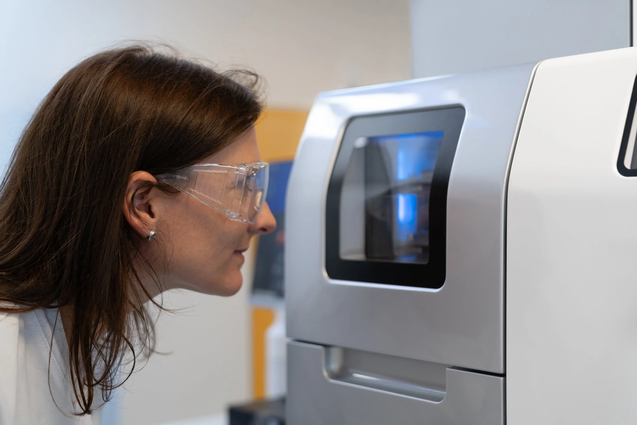 Scientist looking into the observation window of a laboratory instrument