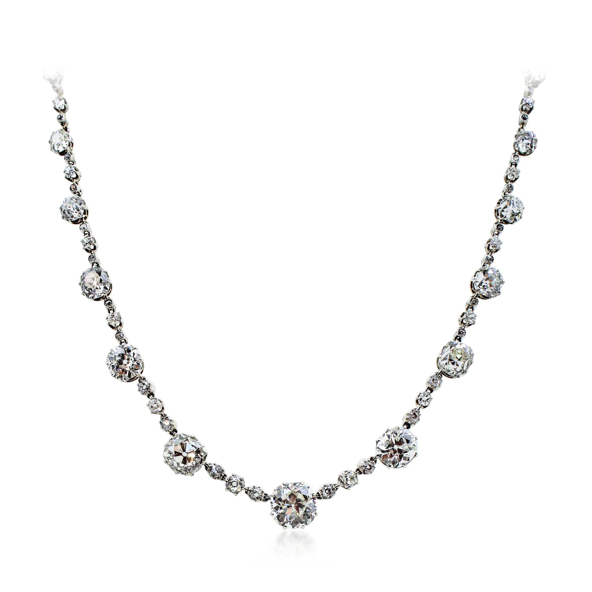 SN7169 - Antique Diamond Rivière Necklace
Designed as a series of twelve graduating old mine-cut diamonds, the three largest weighing 4.85cts, 3.97cts and 2.93cts, each with diamond three-stone spacers between