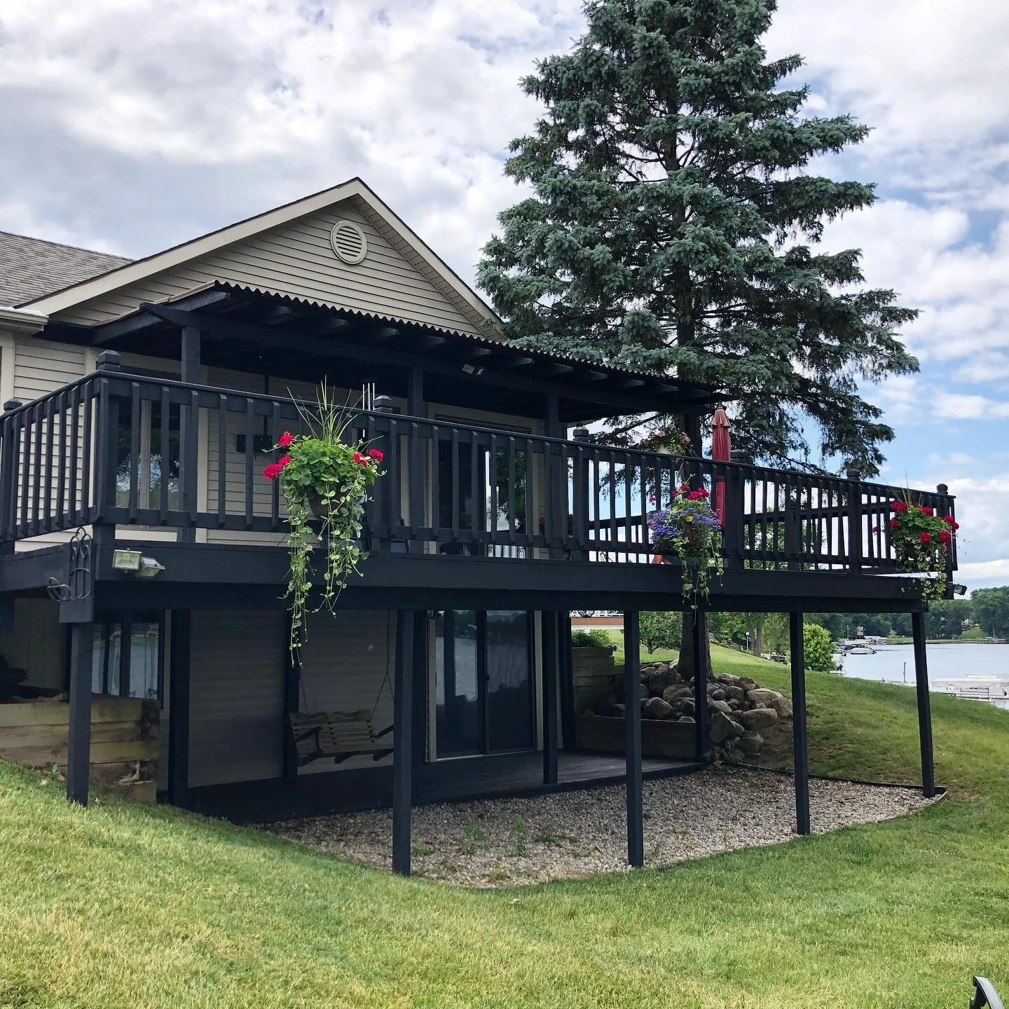 Lake life. This client wanted to stand out from the crowd. They decided they wanted to try something new and went with a black stain. 2nd photo shows the result after pressure washing. 3rd photo is a close up of the red flaking stain they had to star