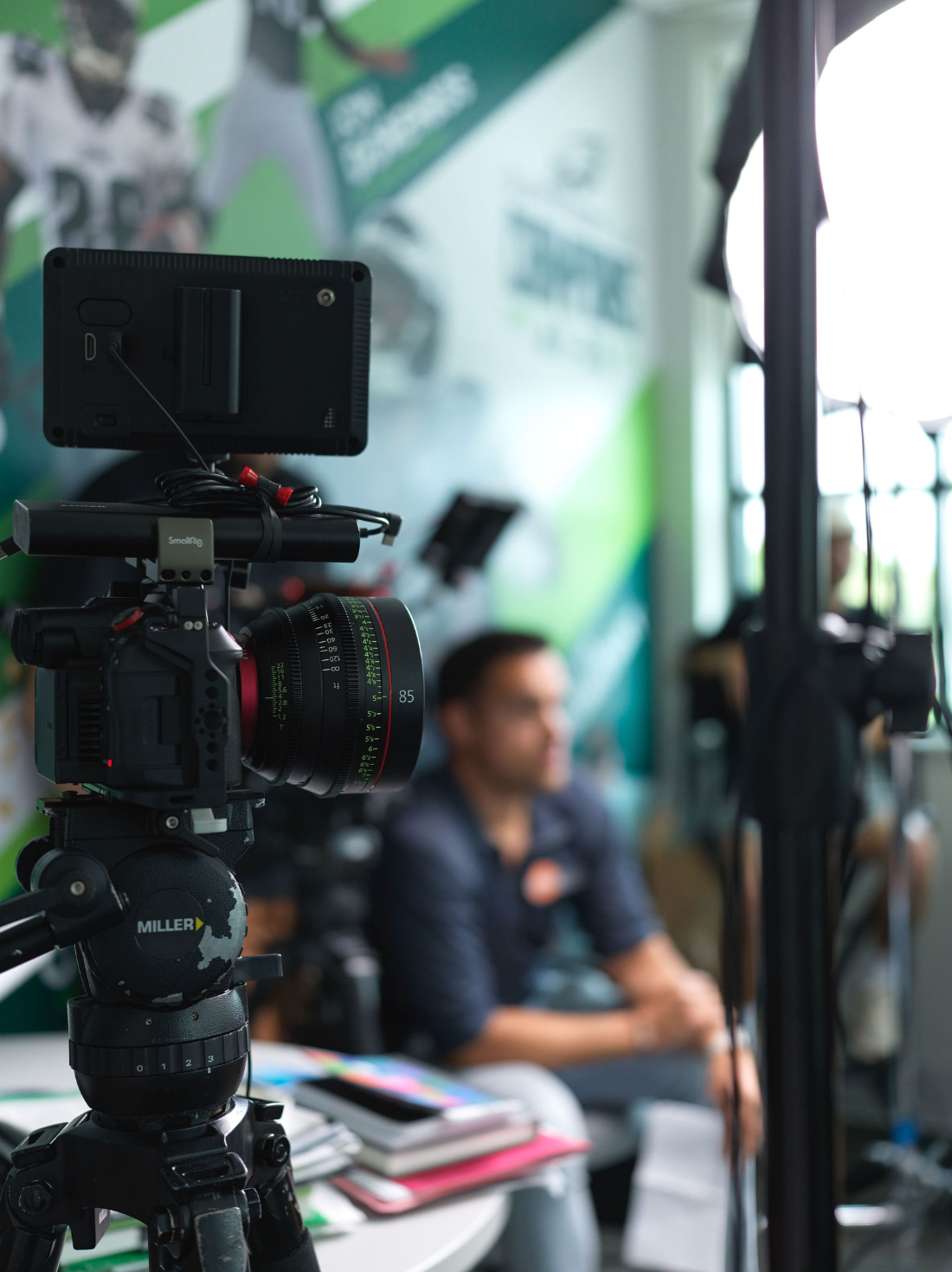 Close-up of a professional video camera mounted on a tripod, with a man capturing effective interview content.